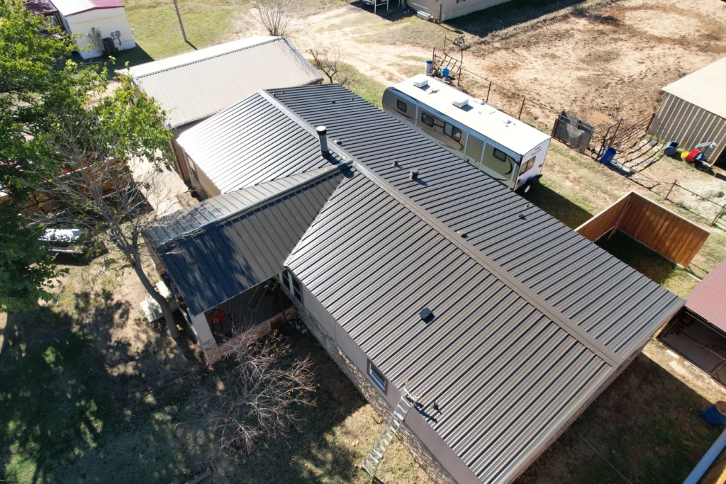 Aerial view of a completed metal roof on a residential property